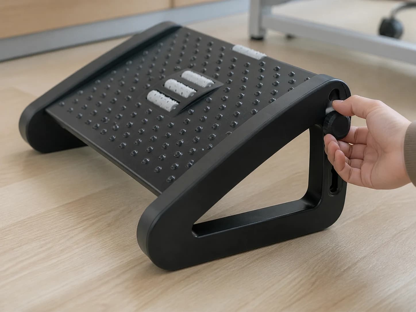 Hand adjusting the side control on the LiftRoll footrest