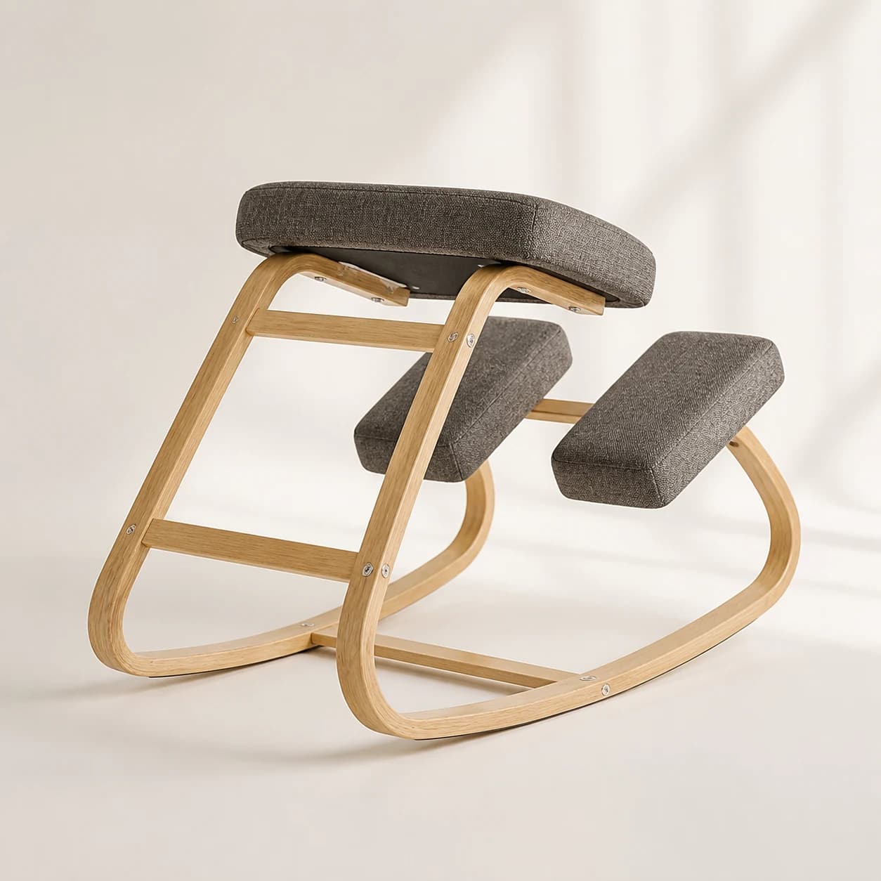Rear three-quarter studio view of the KneelArc seat, knee supports, and curved frame