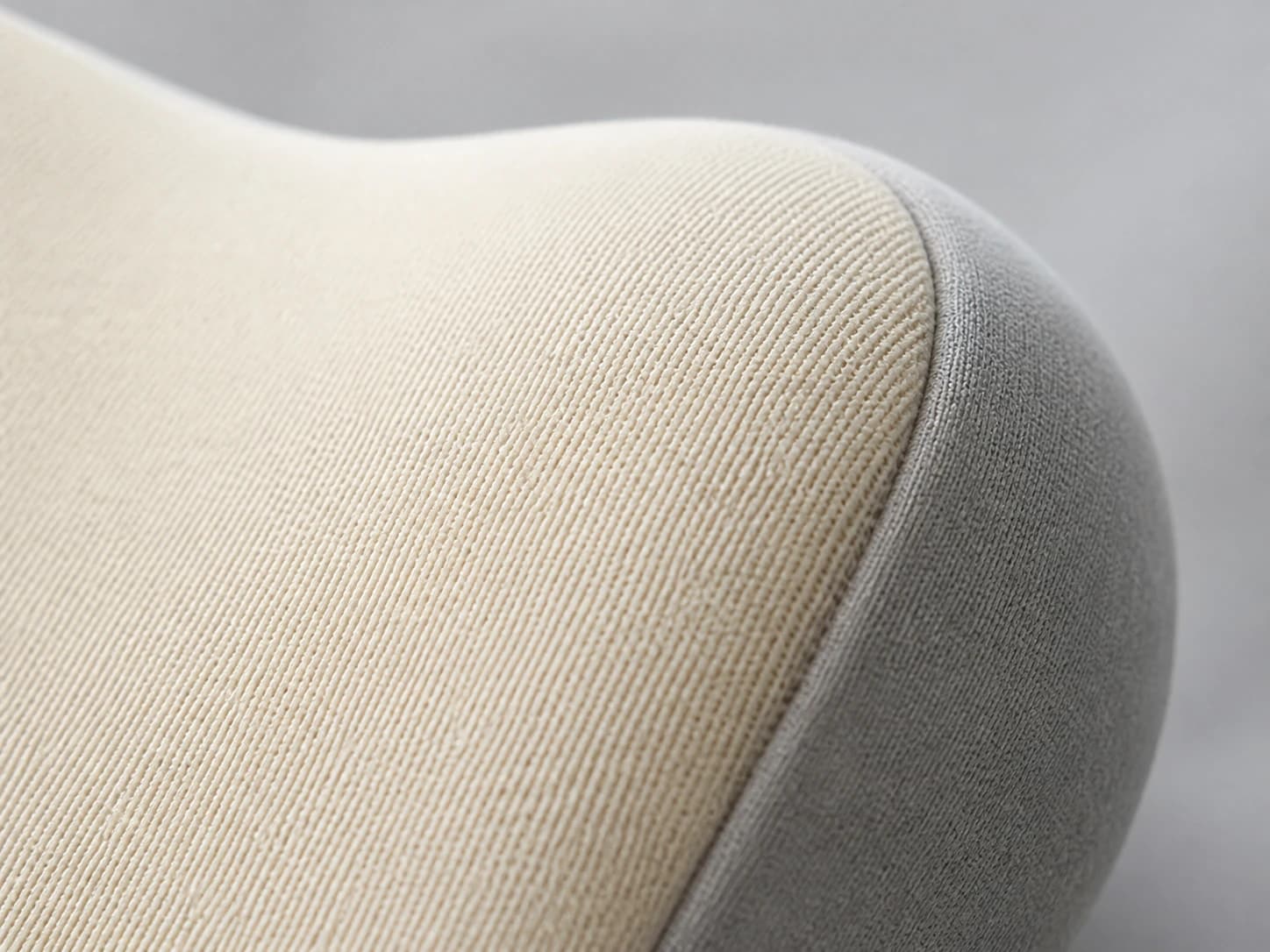 Macro view of DriveNest beige fabric, gray side panel, and seam