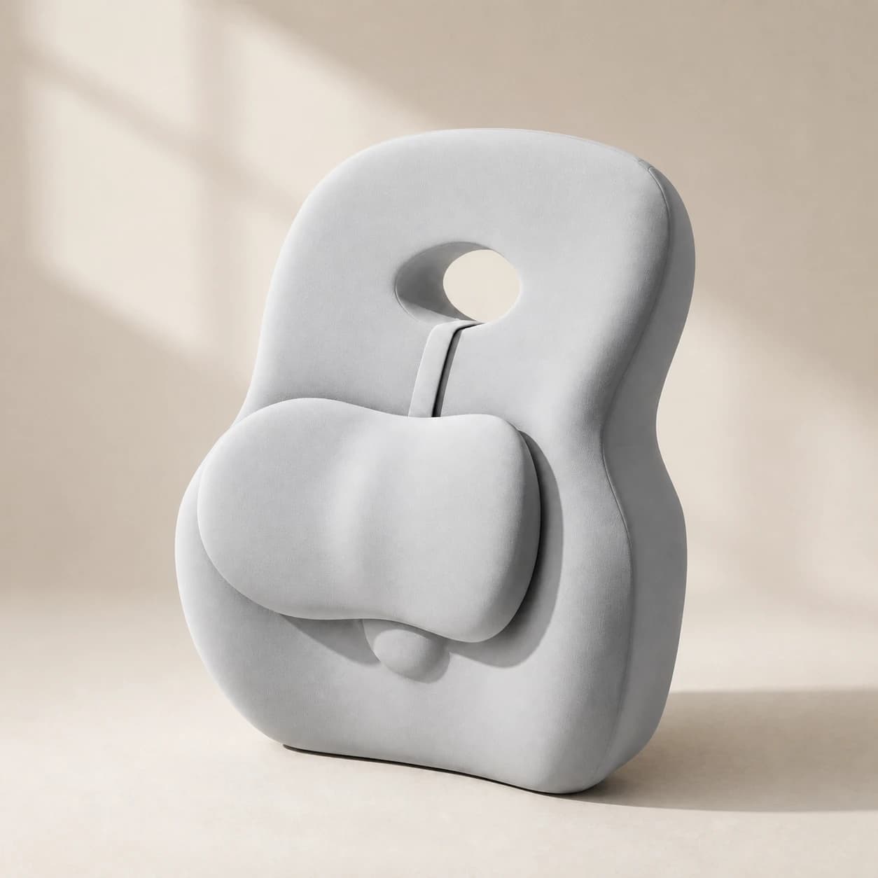 HaloBack volcanic-gray sculpted support cushion on a warm ivory studio set