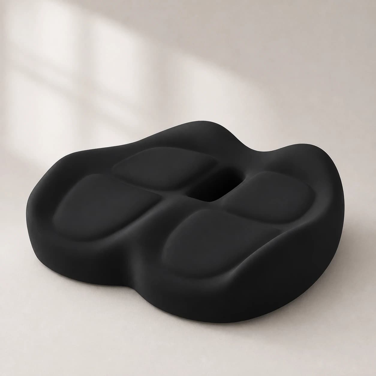 ContourX black sculpted seat cushion on a warm ivory seamless studio floor