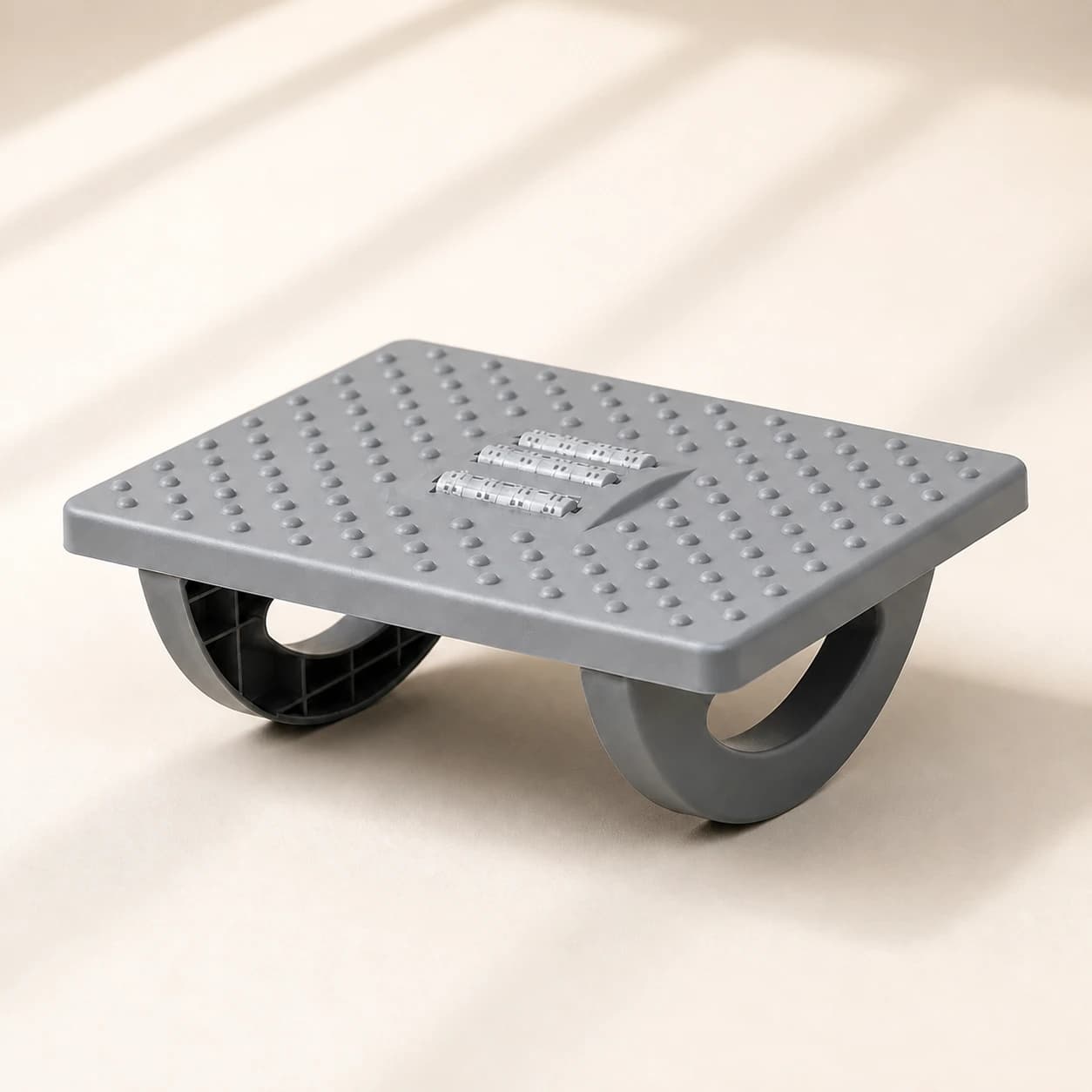 RollArc gray rocking footrest on a warm light studio background