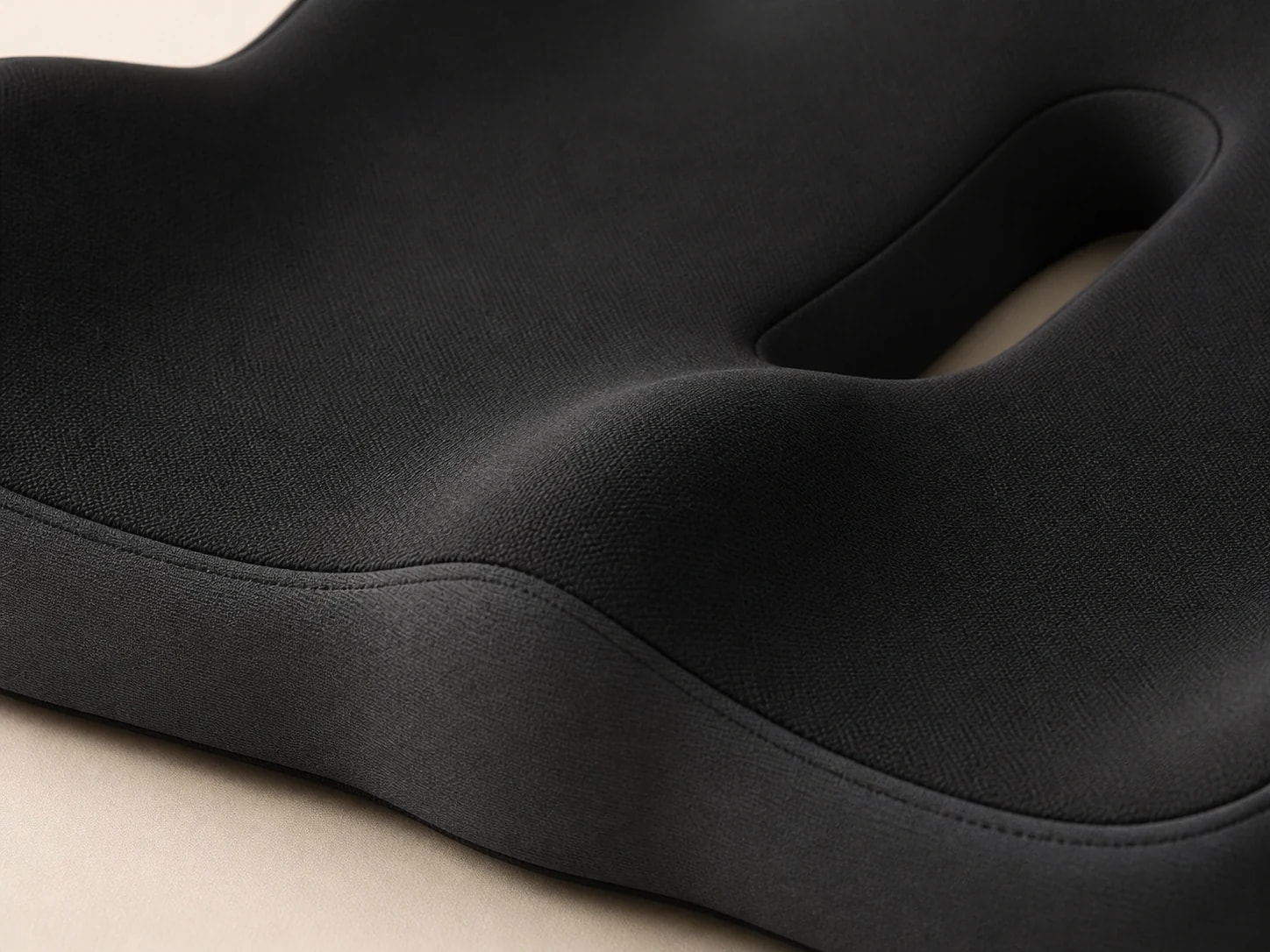 Close-up of the black SeatNest surface, stitched seam, contour, and central opening