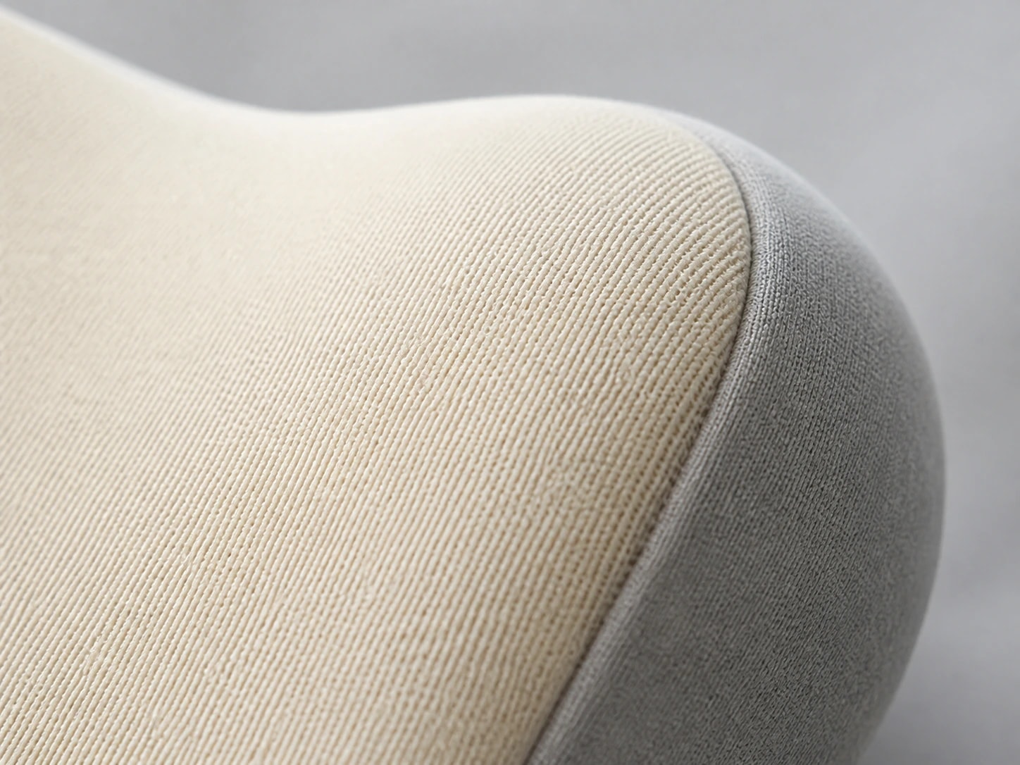 Macro view of DriveNest beige fabric, gray side panel, and seam