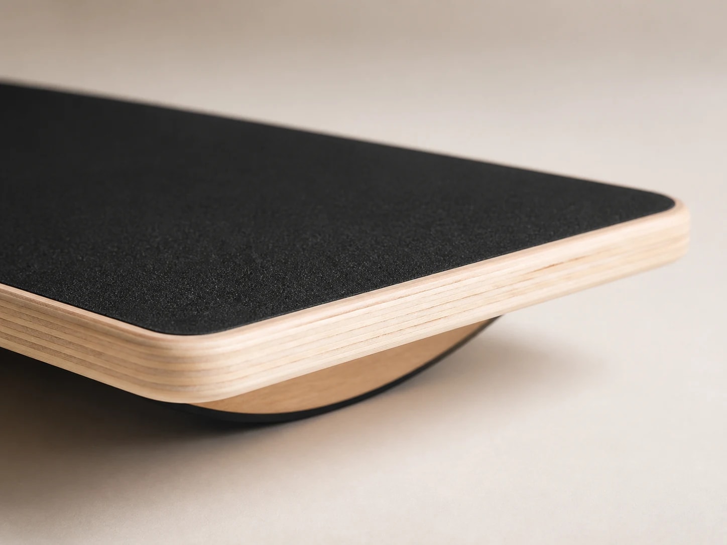 Macro view of the PivotArc black top/contact surface, wooden edge, and curved rocker